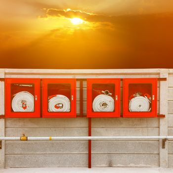 Fire extinguisher equipment on the wall (fire, protection, system) with sunray background.