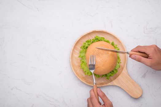 Eating delicious homemade burger on table. Top view, copy space, horizontal