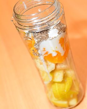 Pieces of a Raw Fruit with Plain Yogurt and Chia Seeds in a Plastic Bottle Before Making a Smoothie Cocktail.