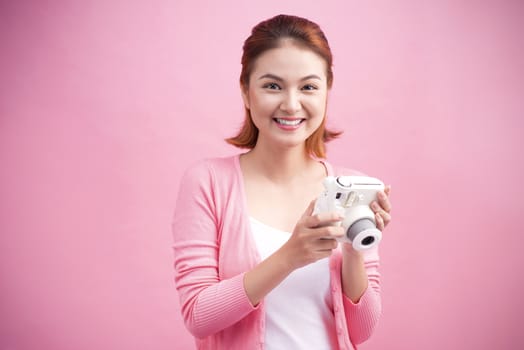 Young woman taking a photo with a camera.
