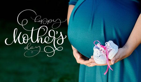 Image of pregnant woman touching her belly with hands and text Happy mothers day. Calligraphy lettering hand draw.