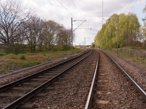 Wonderful shots of day time train tracks as seen standing on the track, no people, no train, in the countryside and forest with trees and plants and safety signs in day time light in summer