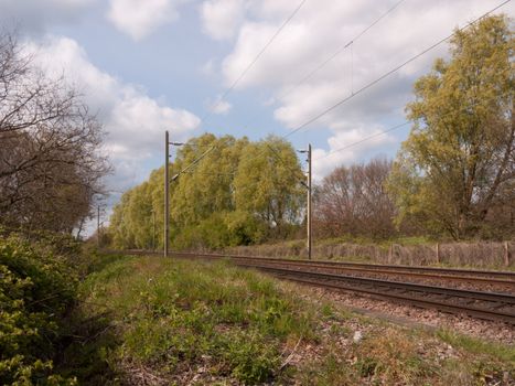 Wonderful shots of day time train tracks as seen standing on the track, no people, no train, in the countryside and forest with trees and plants and safety signs in day time light in summer