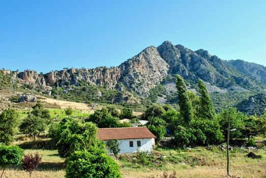 A lonely little house on the background of the mountains.