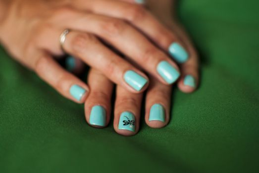 Beautiful manicure made on the nails on the fingers with colored varnish