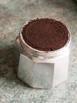 The Bottom Base of a La Cafetiere stove top espresso coffee pot Up Close in the Kitchen and In Light, Plenty of Coffee Grains Packed in, metal Kettle for Energy in the Morning in the UK