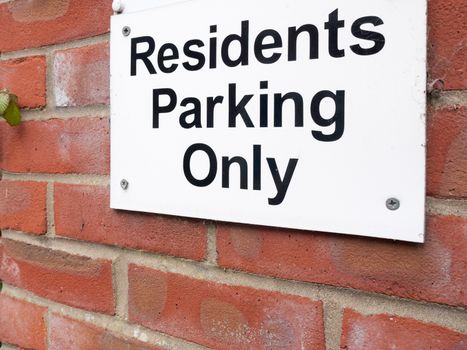 a sign outside near a private residential old people car park saying residents parking only white and black on brick warning restriction english uk motor road car law parking