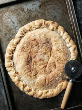 close up of rustic italian calzone stuffed pizza