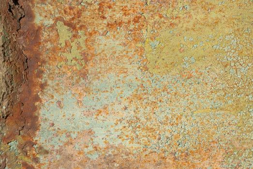 fragment of a rusty iron surface covered with old paint, which has long been under the influence of different climatic conditions