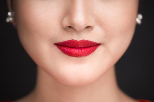 Beauty. Close up view of beautiful woman lips with red matt lipstick