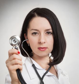 the beautiful woman the doctor with a stethoscope on a white background