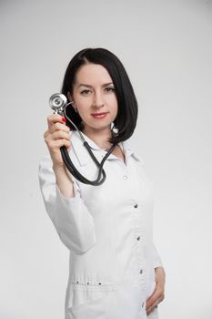 the beautiful woman the doctor with a stethoscope on a white background