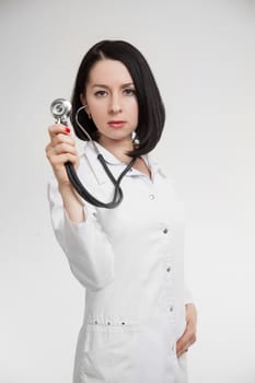 the beautiful woman the doctor with a stethoscope on a white background