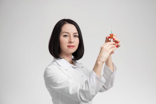 the beautiful woman the doctor with the syringe on a white background