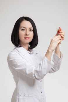 the beautiful woman the doctor with the syringe on a white background