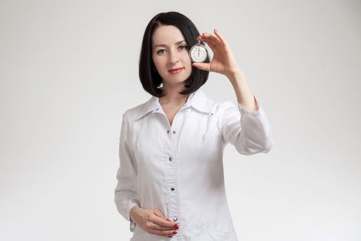 the beautiful woman the doctor with a stop watch on a white background