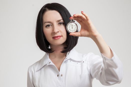 the beautiful woman the doctor with a stop watch on a white background