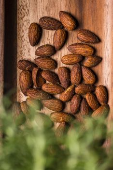 Toasted almonds  in a wood sish over a black board.