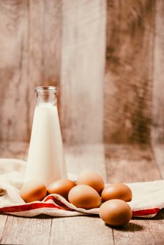 Eggs and milk on wooden background. Copy-space