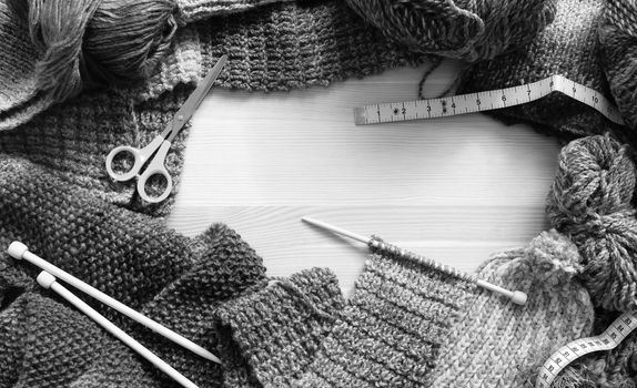 Border of colourful knitting, wool and craft accessories on wooden background