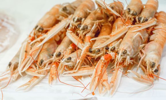 Fresh lobsters on ice for sale at market. Selective focus on the center lobster.