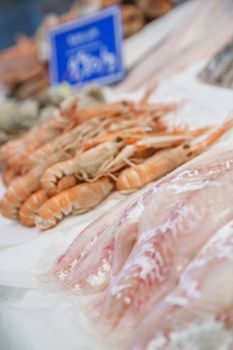 Fresh cod fillet and lobsters on ice for sale at market