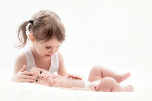 elder sister and the younger newborn child on a white background