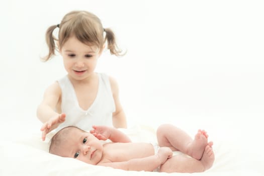 elder sister and the younger newborn child on a white background