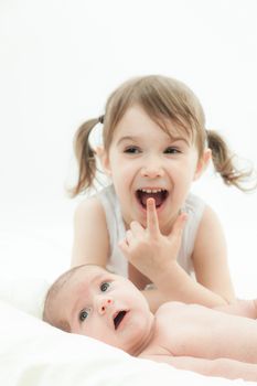 elder sister and the younger newborn child on a white background