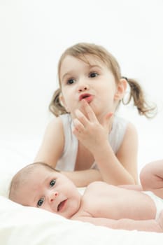 elder sister and the younger newborn child on a white background