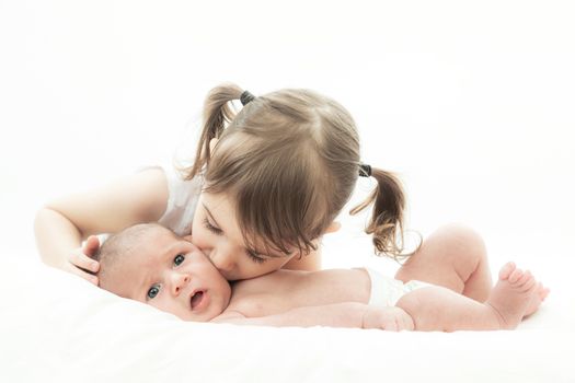 elder sister and the younger newborn child on a white background