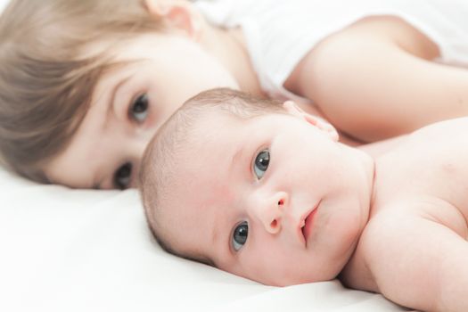 elder sister and the younger newborn child on a white background