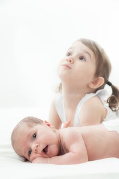 elder sister and the younger newborn child on a white background