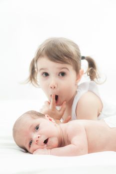 elder sister and the younger newborn child on a white background