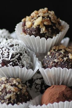 Chocolate muffins sprinkled with crushed nuts and coconut.