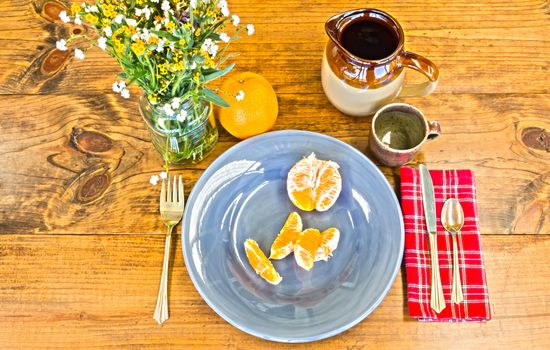 Place Setting With Orange Peels and Brown Cup on Wooden Table With Knots