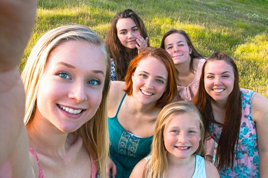Group of Cute Young Girls  Taking a Selfie with Green Grass in the Background