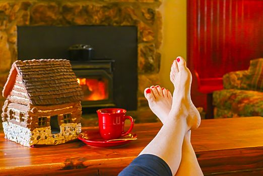 Feet Resting by the Fireplace With a Steaming Hot Cup of Tea