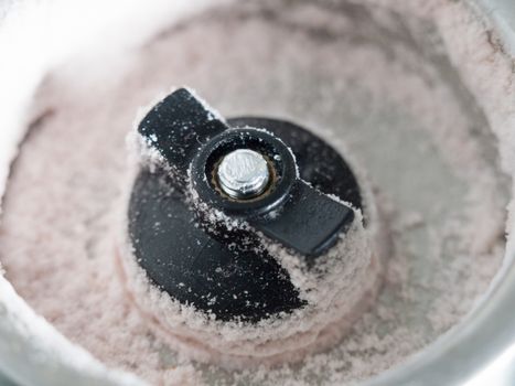 close up macro of the bottom of a salt shaker dispenser with grains of salt in detail