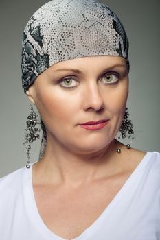 Portrait of beautiful middle age woman patient with cancer wearing headscarf, hope in healing. She lost her hair