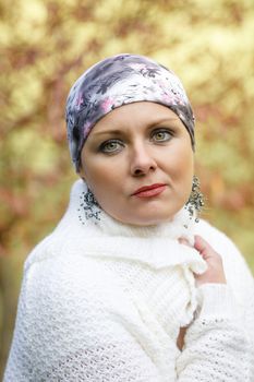 Portrait of beautiful middle age woman patient with cancer wearing headscarf outdoor, hope in healing. She lost her hair
