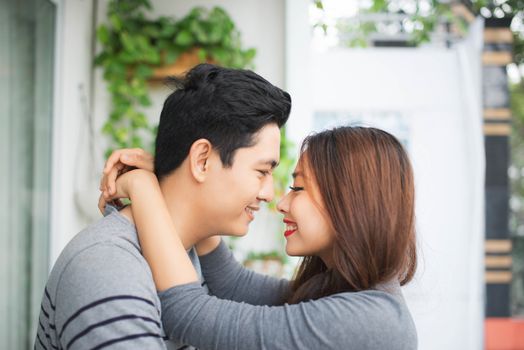 Couple in love sharing genuine emotions and happiness, hugging on the balcony