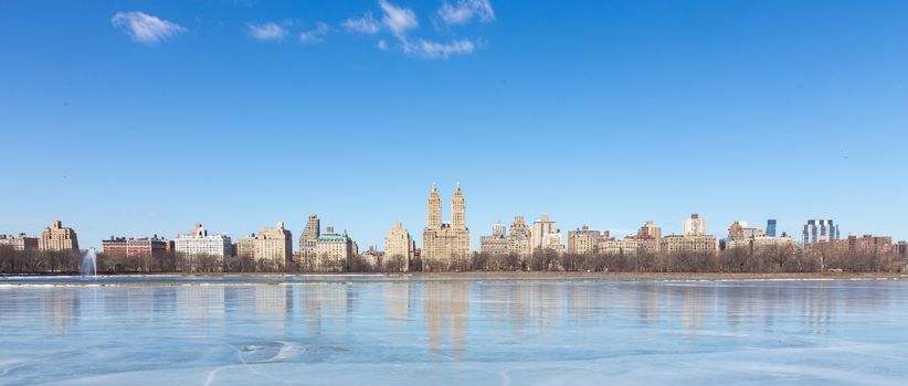 New York City - Panoramic view of modern buildings from Central Park with Jacqueline Kennedy Onassis Reservoir.