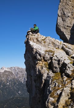 Young backpacker sitting on the edge of a cliff