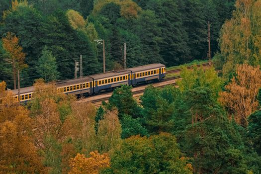 Passenger electric train moving through the forest in Riga