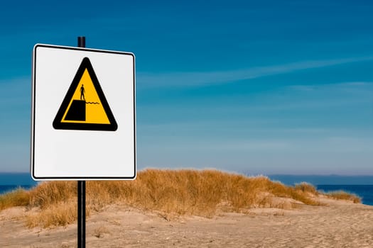 Yellow warning sign on summer beach, Riga