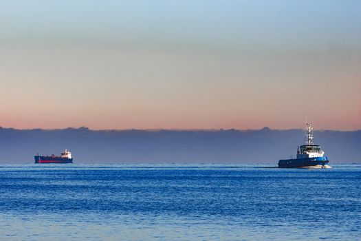 Blue small tug ship sailing from the Baltic sea in the morning