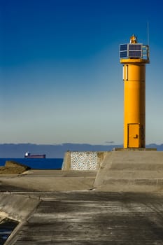 Yellow lighthouse on breakwater dam in Riga, Europe