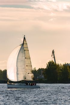 Sailboat moving on Daugava river in evening, Latvia