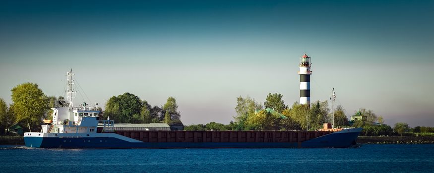 Blue cargo ship leaving Riga and entering Baltic sea